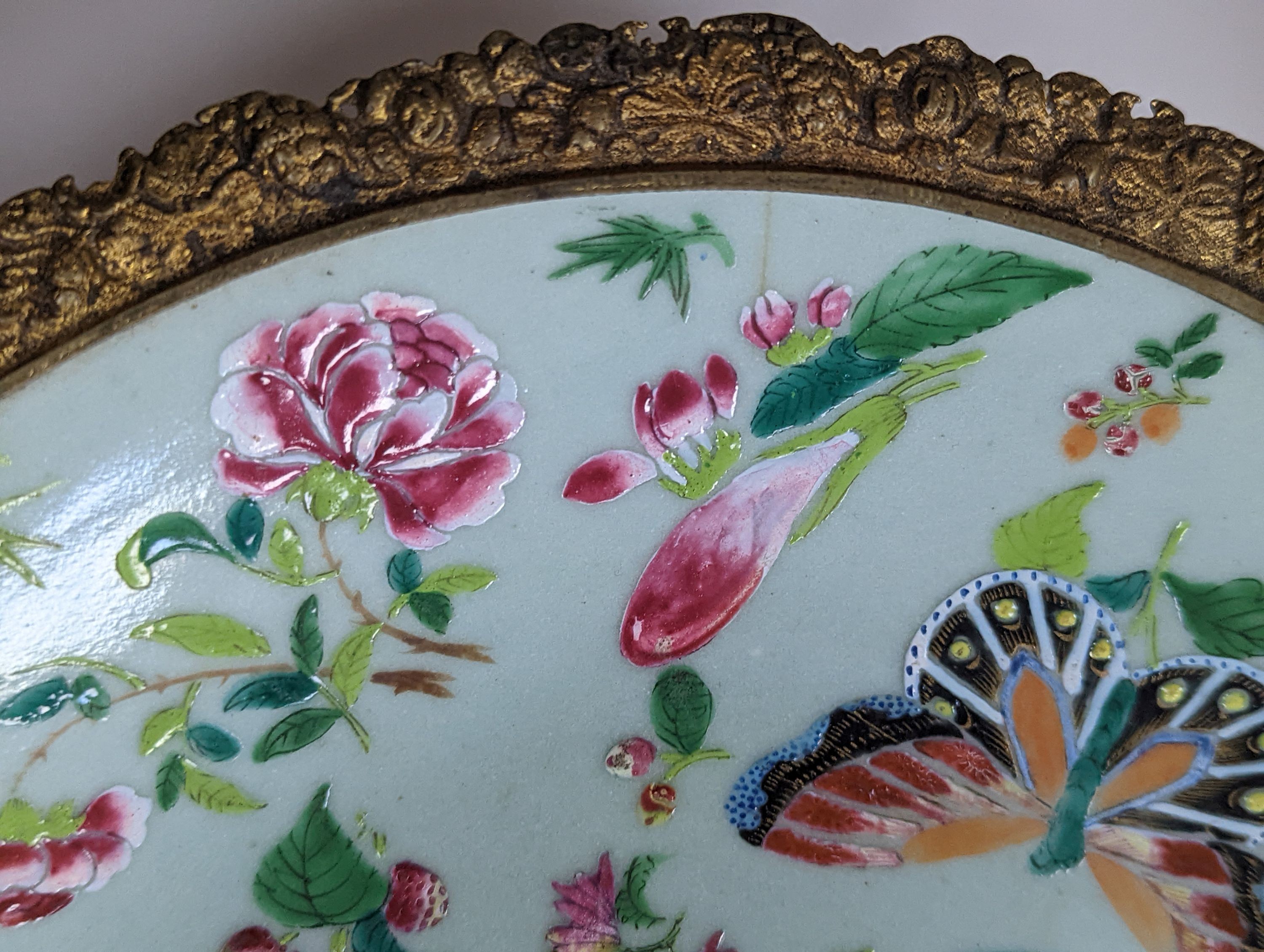 A 19th century Chinese famille rose dish with ormolu mount, 29 cms diameter.